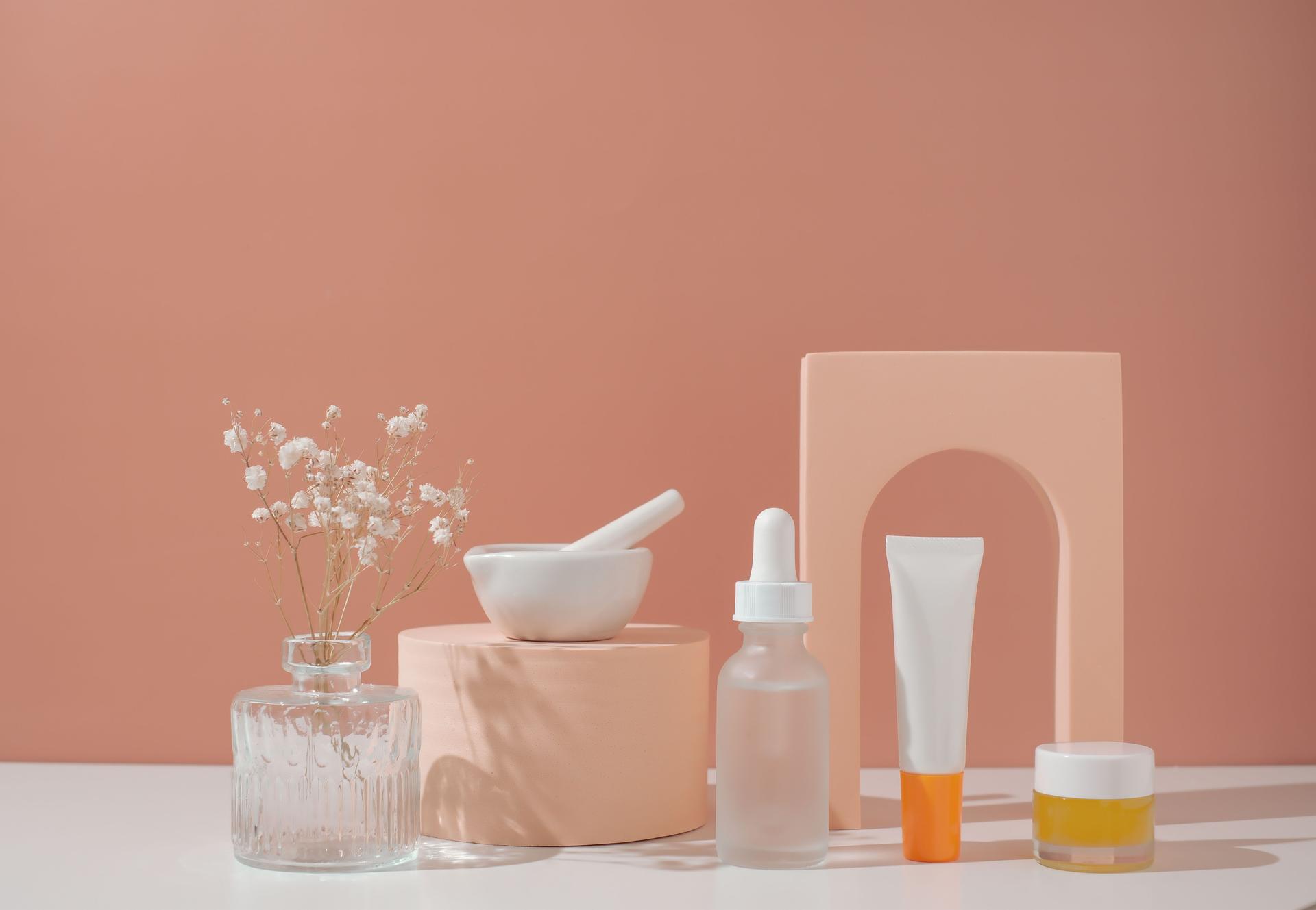 Skincare and beauty product on pastel background with flower.