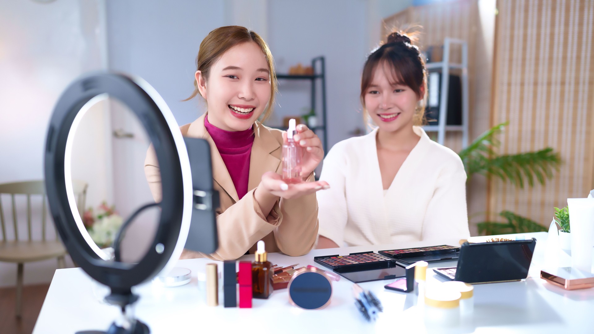 Asian Women Reviewing Cosmetic Product for Beauty Vlogs on Social Media Platform with Ring Light at Home for Beauty Blogging