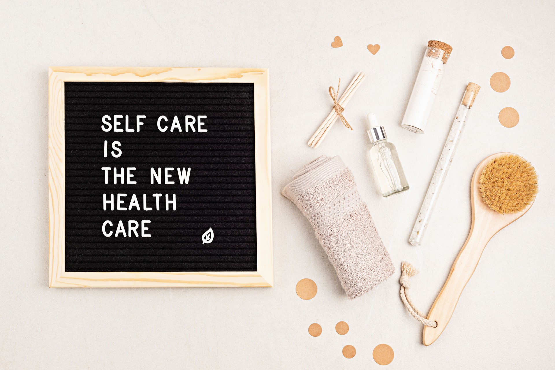 Self care is the new health care. Motivational quote on black letter board with variety of organic body and face care products. Natural homemade eco friendly beauty products